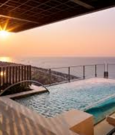 View of a luxurious pool with a sunset in the background